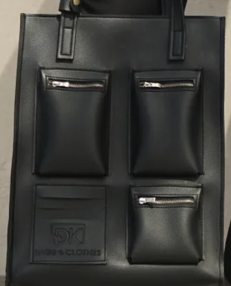 Close view of the DK 01 Moscow front: three zipped pockets with metal zips and a flat panel carrying the DK mark.
