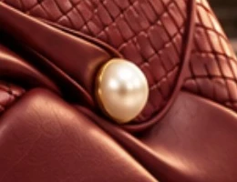 DK Shanghai. Pearl-inspired closure: A single pearl detail on the sweeping flap.